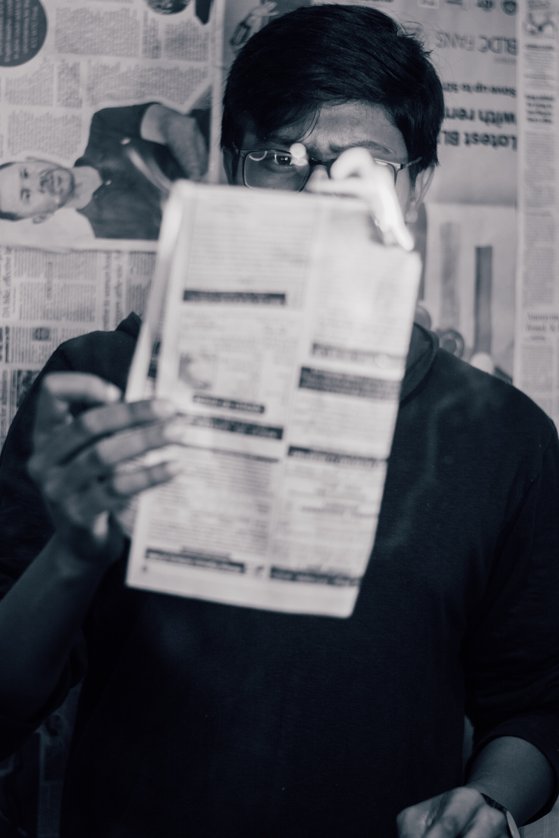 a black and white photo of a person holding up a piece of paper