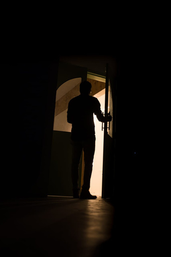 a silhouette of a person standing in a dark room